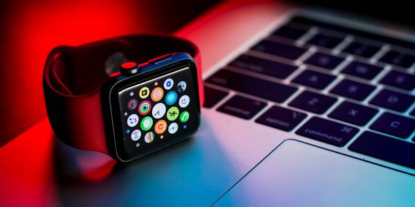 An Apple Watch sitting on an Apple Macbook