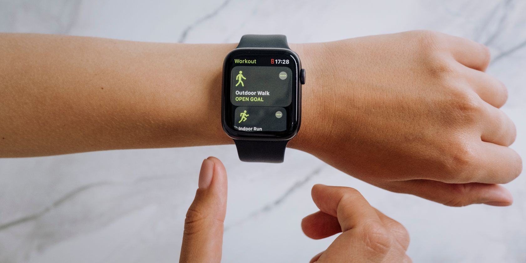 An Apple Watch pinch athletics set displaying an outdoor locomotion workout