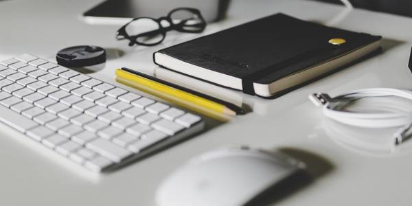 Habit-tracking journal beside keyboard and mouse