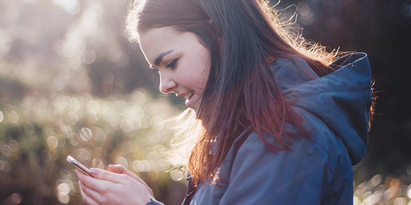 Woman smiling at a smartphone