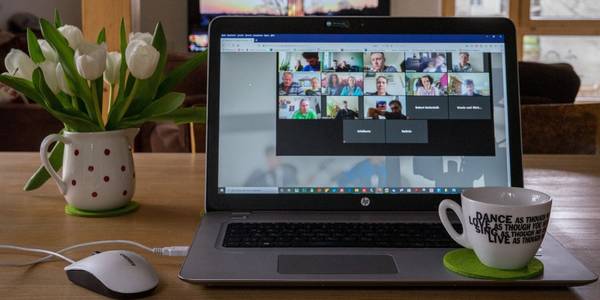 Image of a laptop on a desk, with an ongoing online meeting window