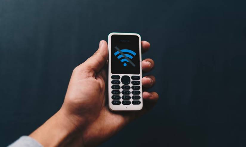 A hand holding an old Nokia phone