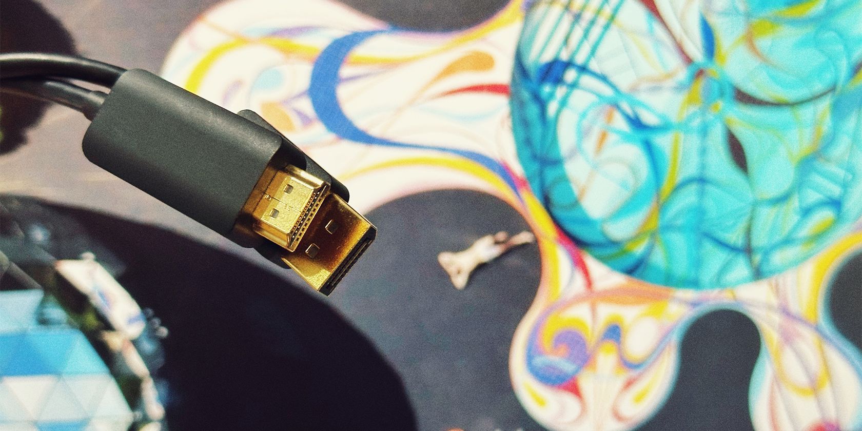 An HDMI and a DisplayPort cable in front of a monitor