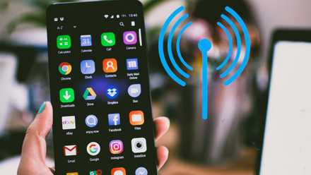 Hand holding an android phone with app icons and network icon