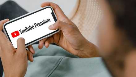 music Man Sitting Down and Watching YouTube Premium on Mobile Phone