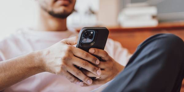 A man relaxes in a living room using an iPhone