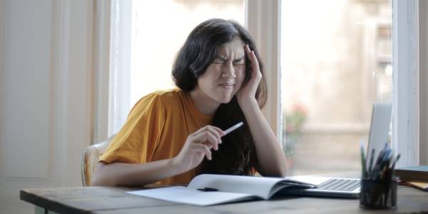 female student sitting at desk and struggling with homework