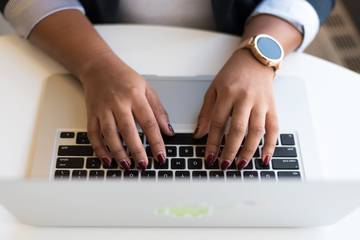 Hands typing on a laptop