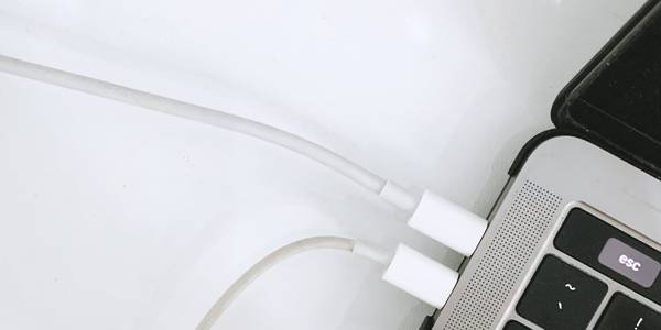 a laptop is connected to two charging cables