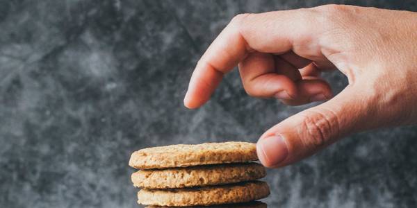 A man reaching for a stack of cookies