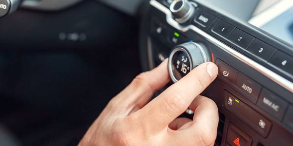 person changing the temperature control in a car