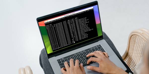 Man using MacBook with Terminal window on screen