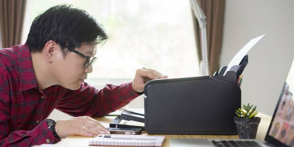 Man looking at printer on a desk