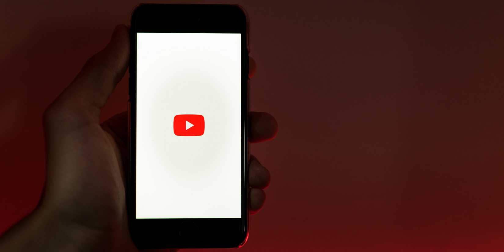 Person holding phone with YouTube logo