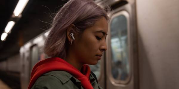 person wearing AirPods Pro on a subway