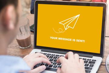Man working on laptop and sent an email to someone at outdoor cafe
