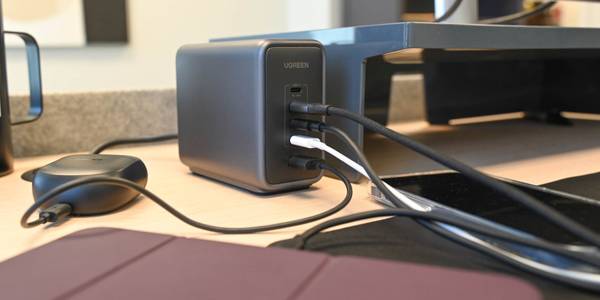 UGreen Nexode 300W charger on a table with four devices plugged in.