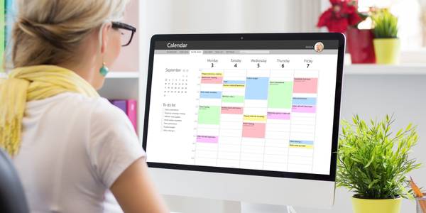 Woman using calendar app on computer in office