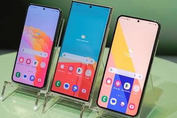 Three Samsung phones showcased on a table at a show
