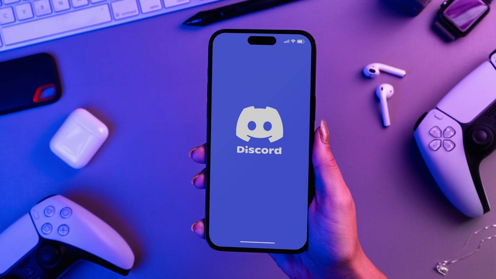 a person holding a smartphone with the discord logo