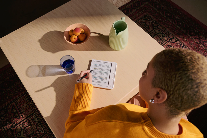 a woman writes at her desk with the kobo libra colour tablet