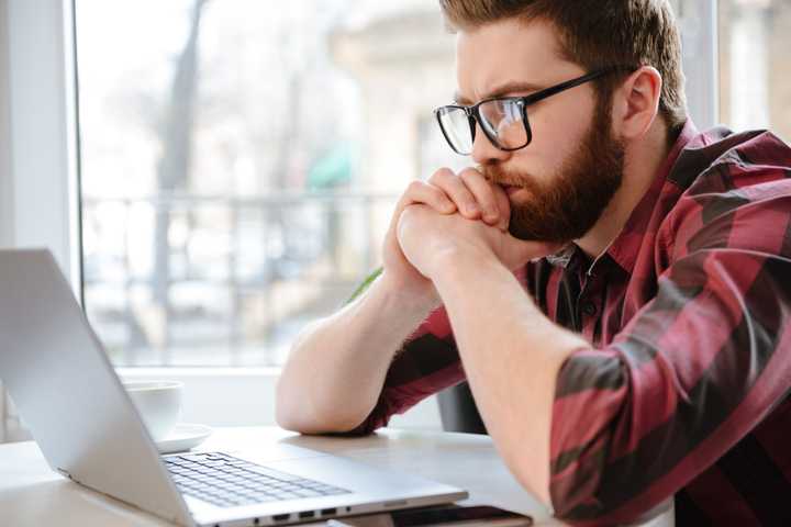 Man Intently Looking at a Laptop