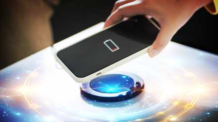 person touching smartphone to wireless charging point