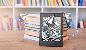 A Kindle leaning against a stack of books with an illustration related to sending around it.