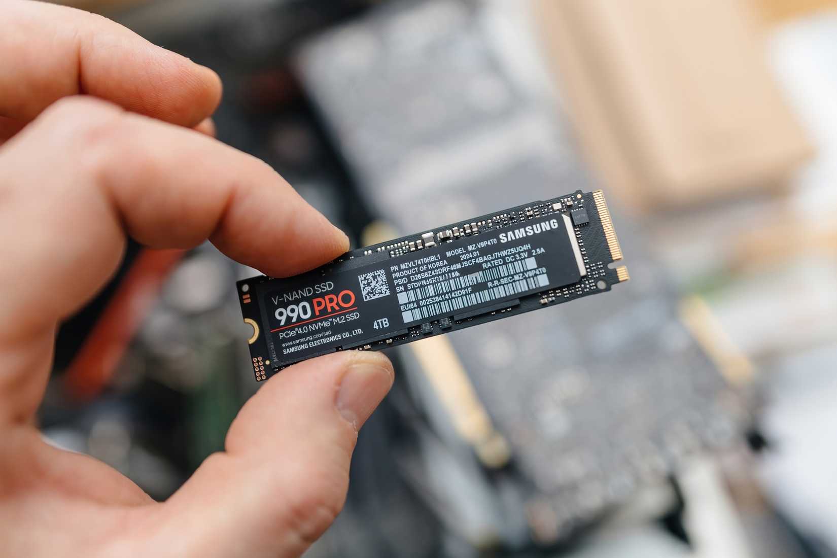 A man holding a Samsung 990 Pro SSD