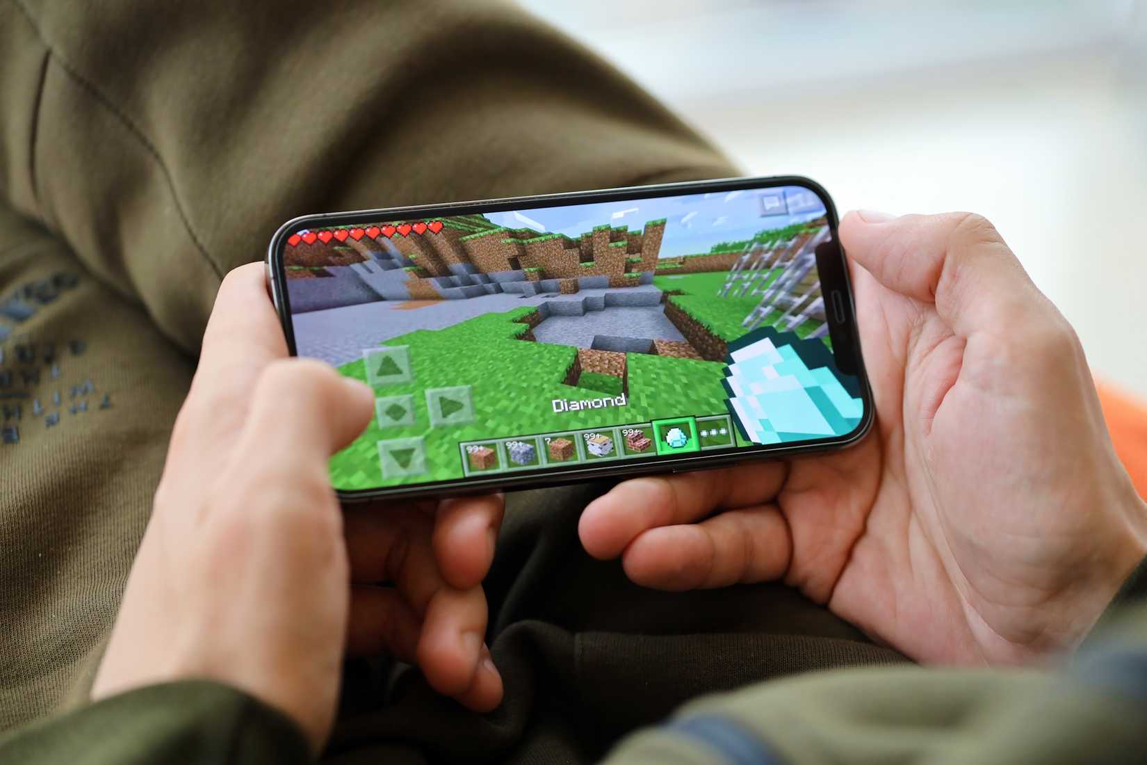 A man playing Minecraft on an iPhone