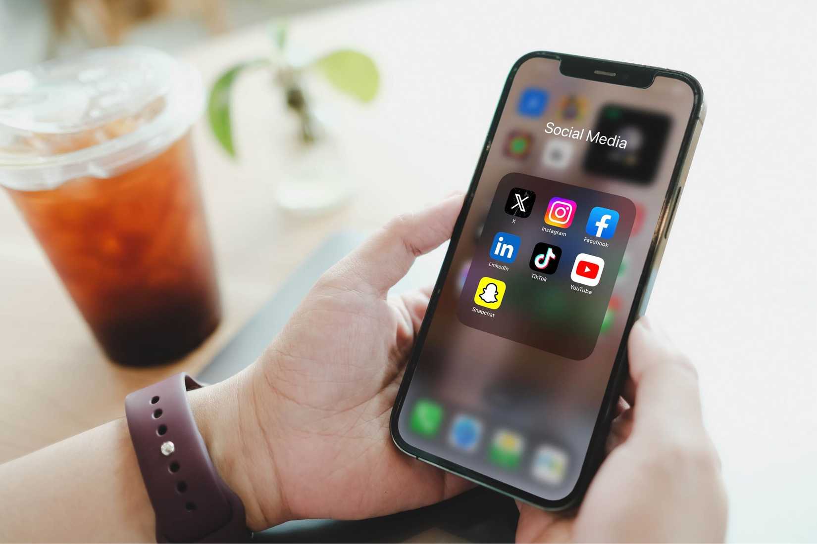 a person holding a smartphone with social media app icons