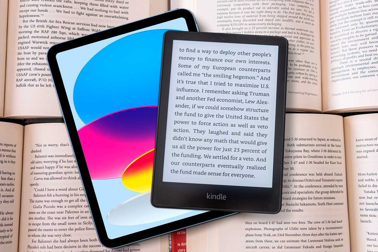 An iPad and a Kindle on top of some books.