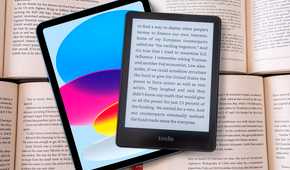 An iPad and a Kindle on top of some books.