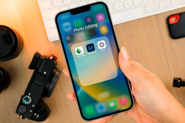 An iPhone with some photo editing apps in the app folder