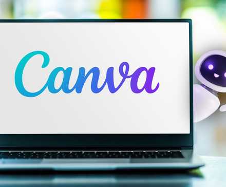 کاراکتر رباتیک هوشمند پشت لپتاپ که لوگوی Canva را نشان میدهد