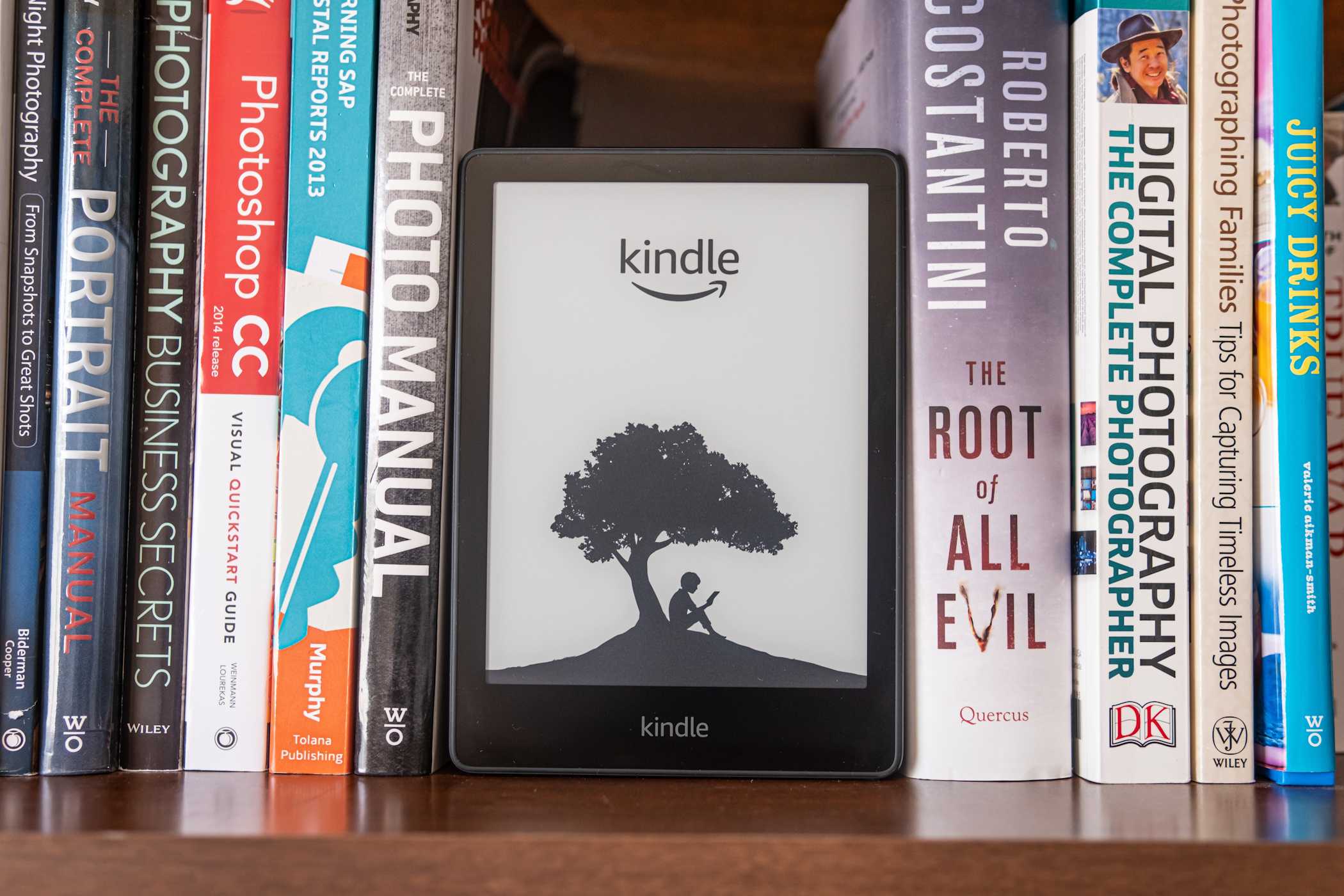 amazon kindle on bookshelf with real books