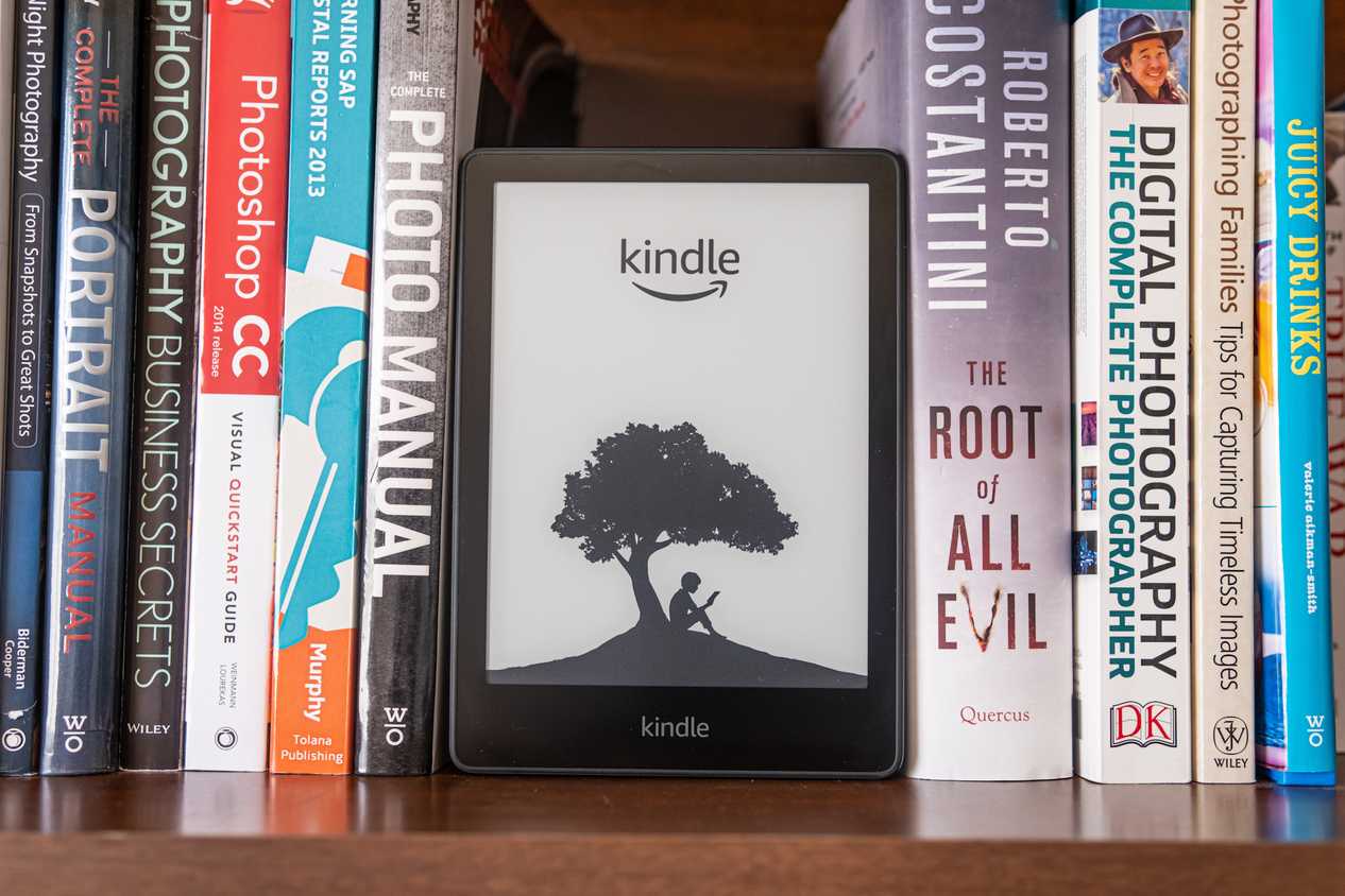 amazon kindle on bookshelf with real books