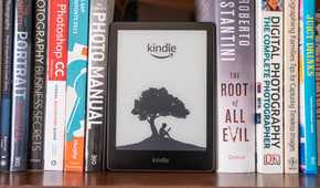 amazon kindle on bookshelf with real books