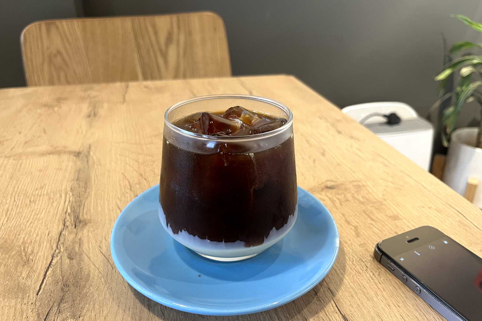 Photo of a glass of cold brew coffee on a table clicked using an iPhone 14