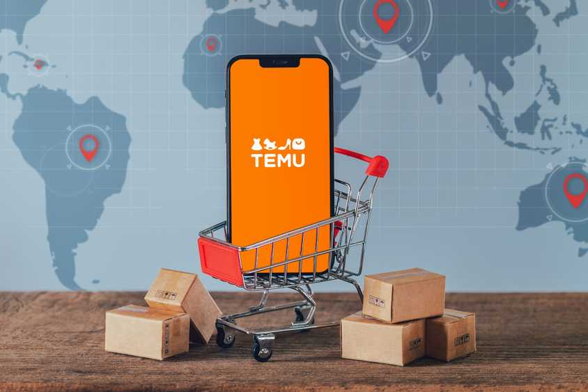 temu logo on smartphone in tiny shopping trolly