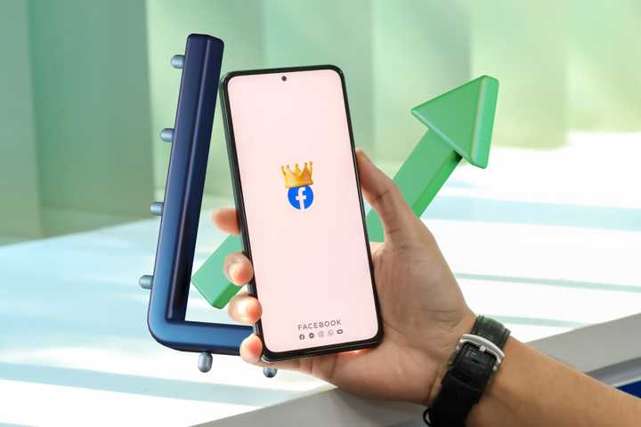 a smartphone with the facebook app held in someone's hand