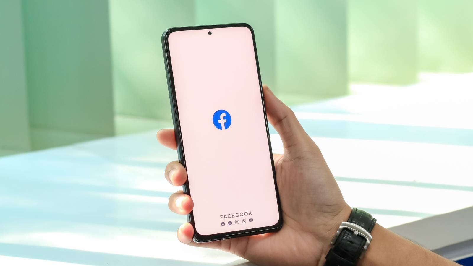 a smartphone with the facebook app held in someone's hand