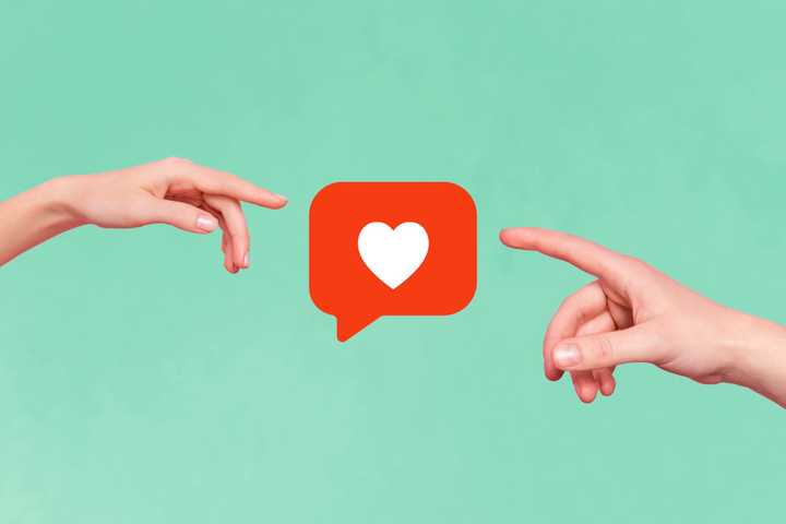 two hands reaching towards each other with a like button in the middle