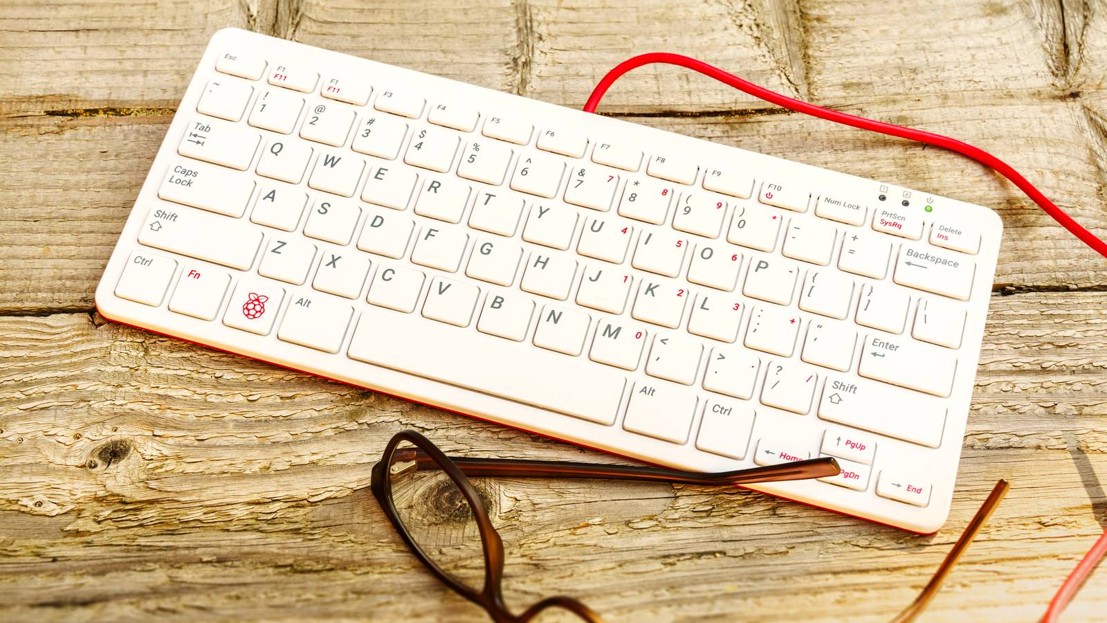 raspberry pi 400 on wooden background with cable