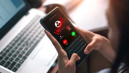 woman answering smartphone call with scam alert