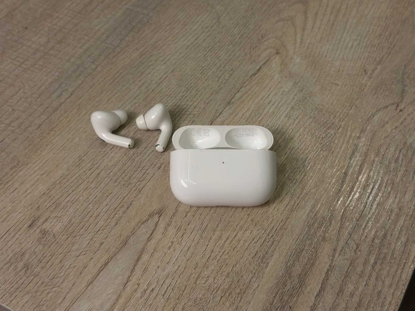Estuche de carga de airPods y brotes que se encuentran en una mesa
