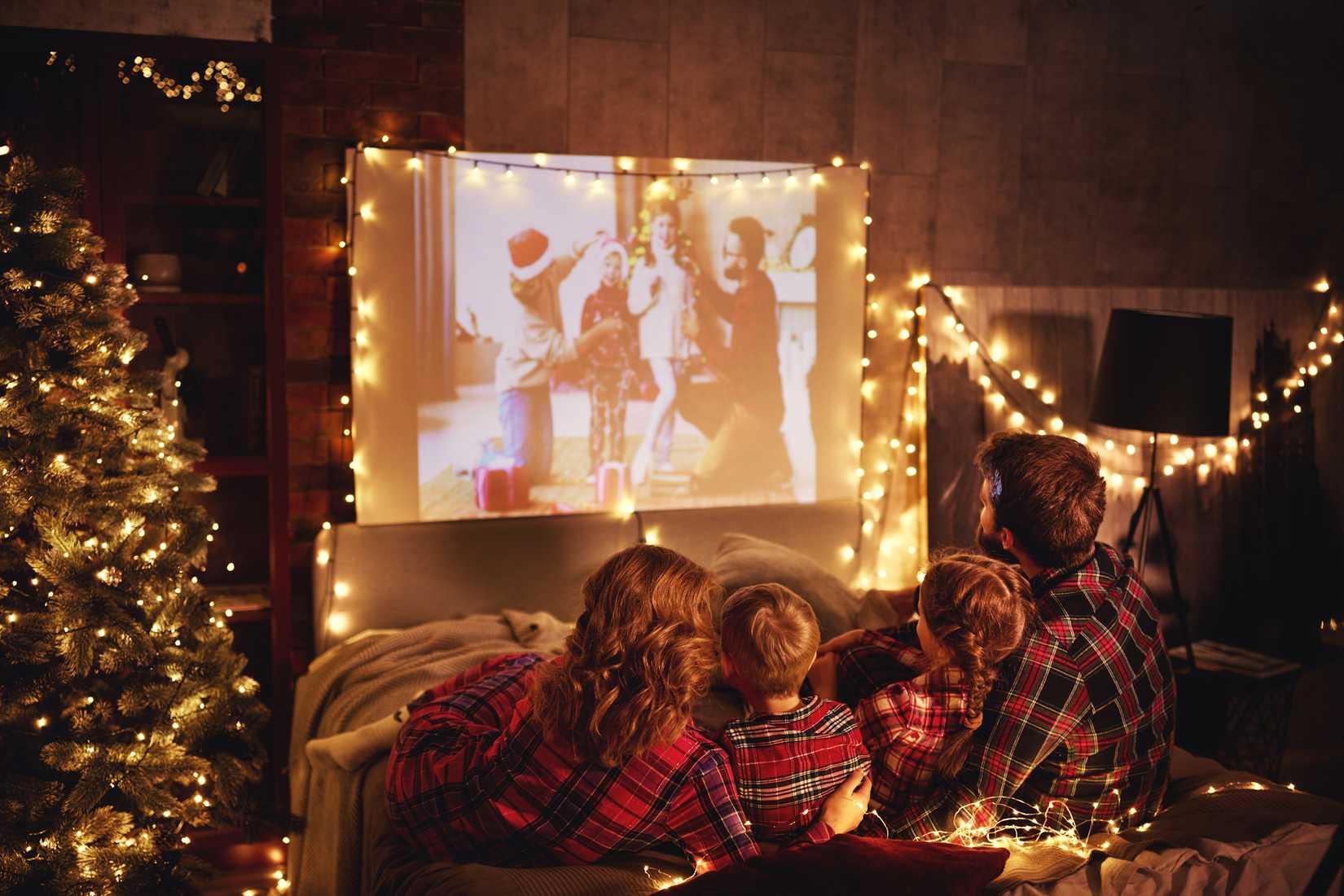 family watching christmas film on projector holiday period