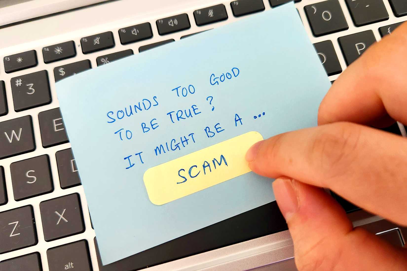 investment scam note on laptop keyboard