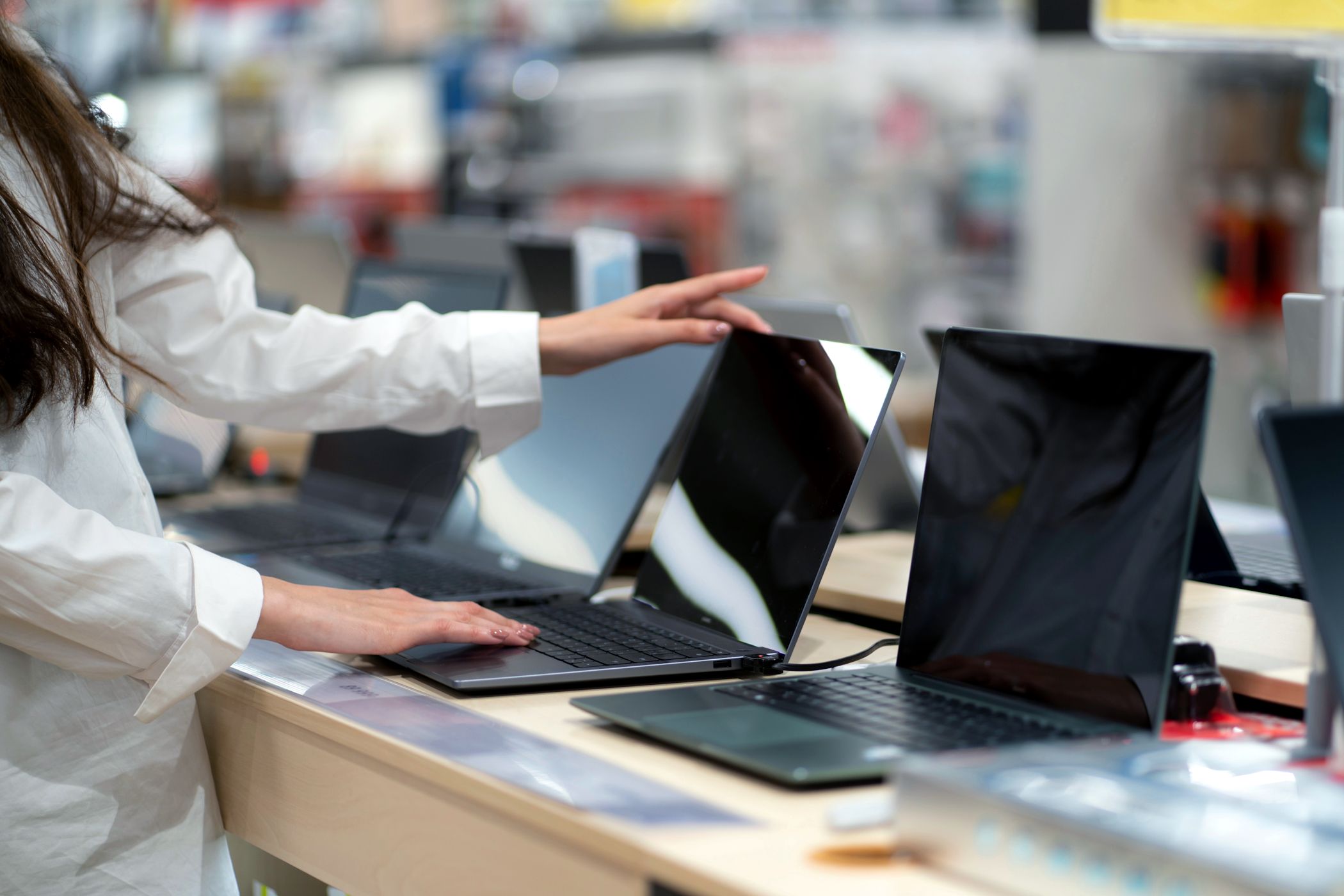 woman shopping for new laptop in store