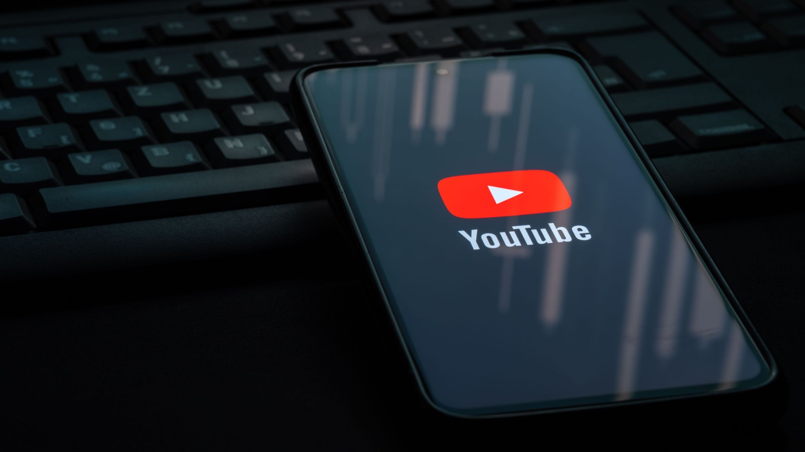 YouTube Logo on Smartphone resting on a keyboard